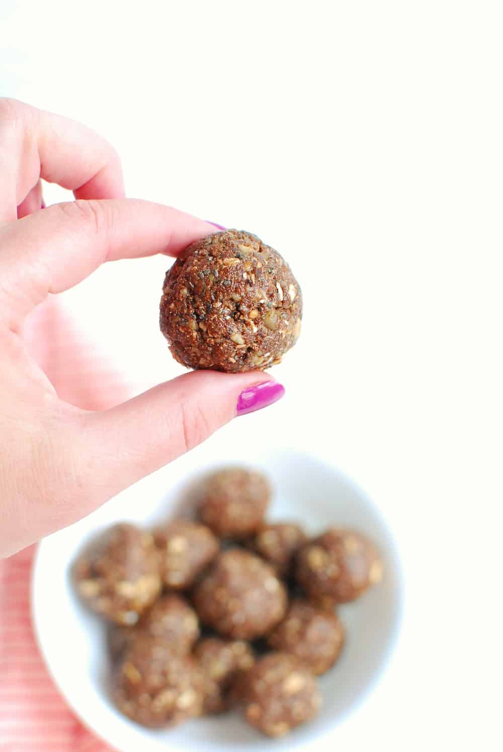 a woman holding one coffee protein ball