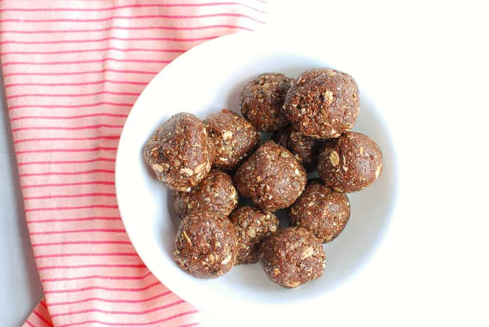 A bowl of coffee energy balls next to a pink napkin