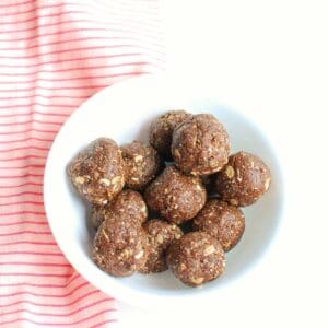 a bowl of coffee protein balls next to a pink napkin