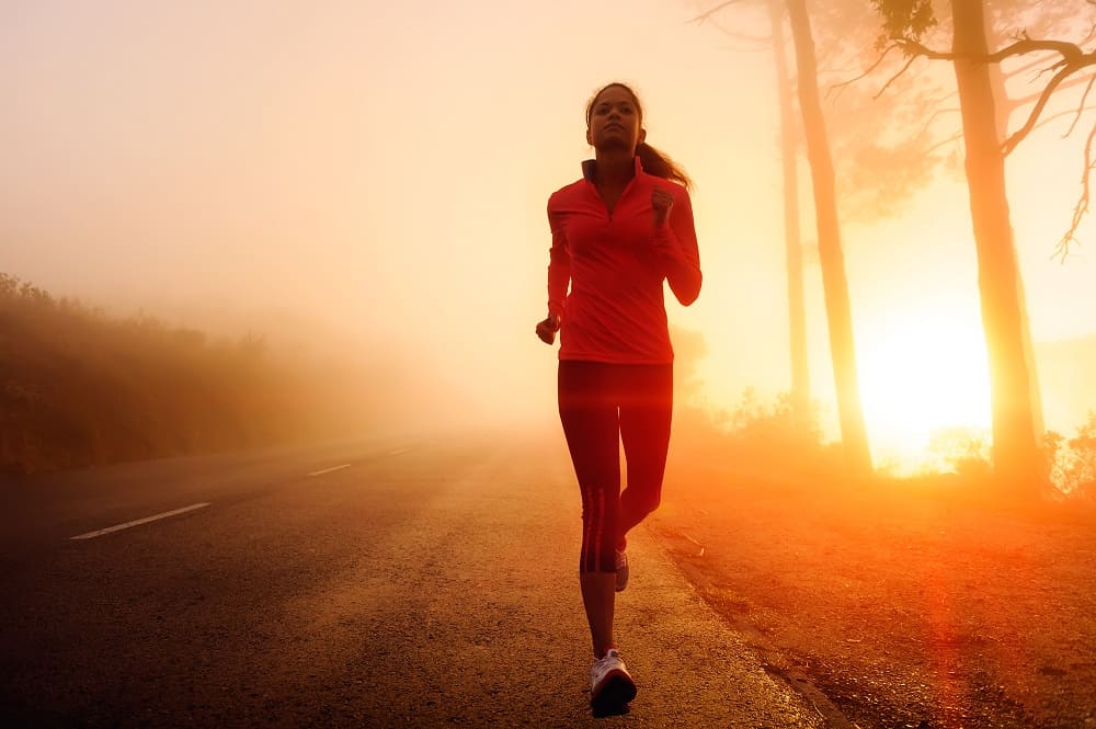 a woman running outside during sunrise