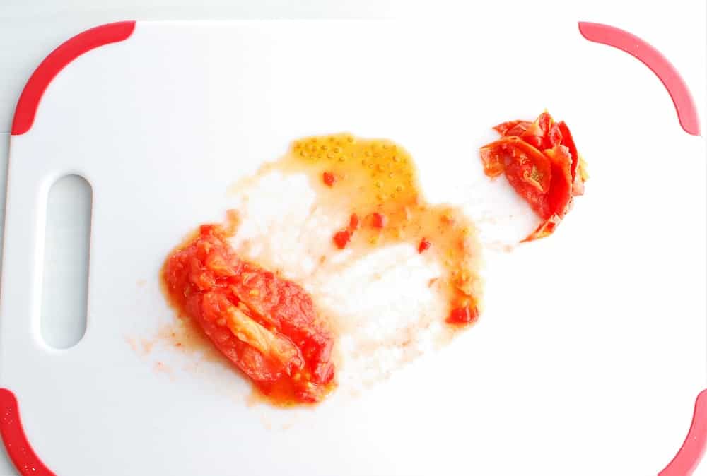 a peeled and deseeded tomato on a cutting board