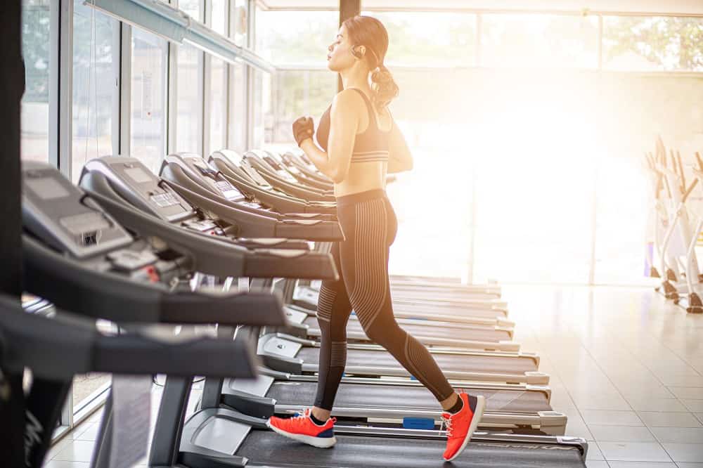 a woman running on a treadmill inside a gym