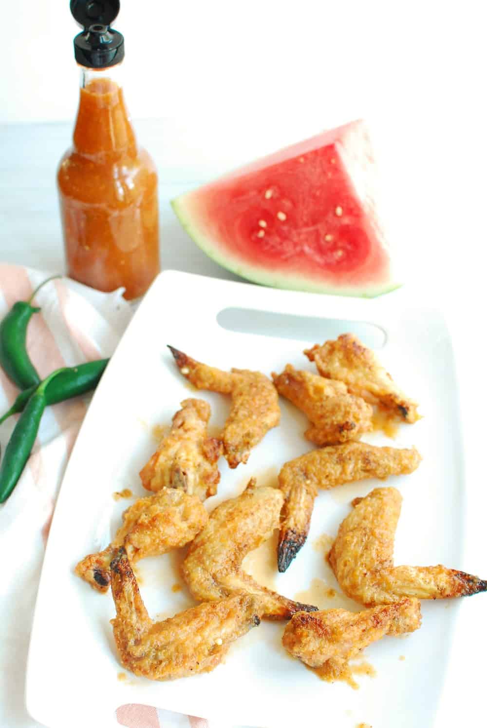 a platter full of baked chicken wings tossed in watermelon hot sauce