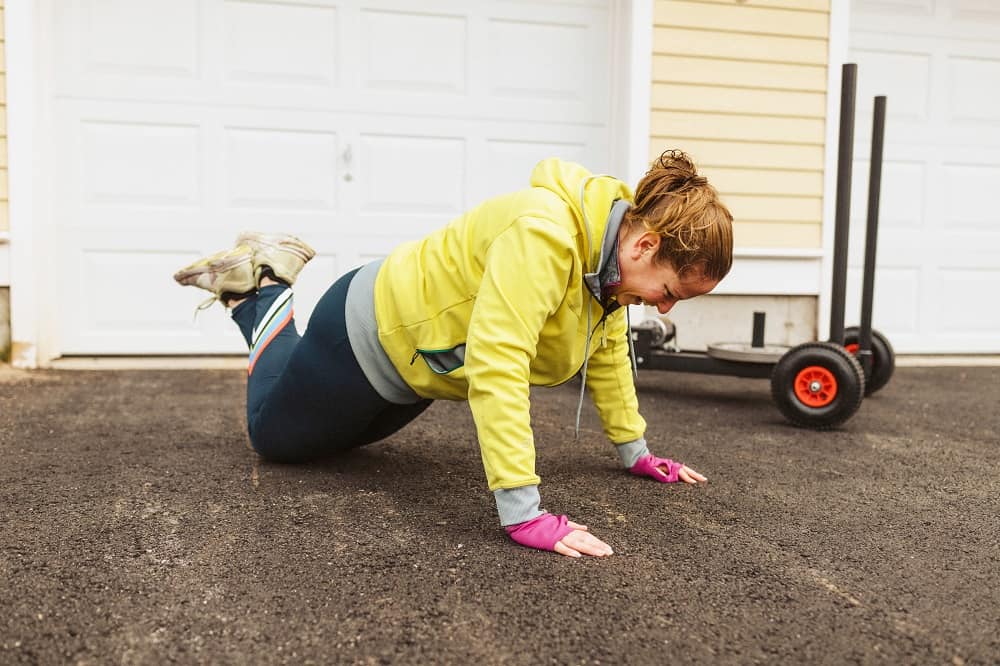 a woman in a modified pushup position outside