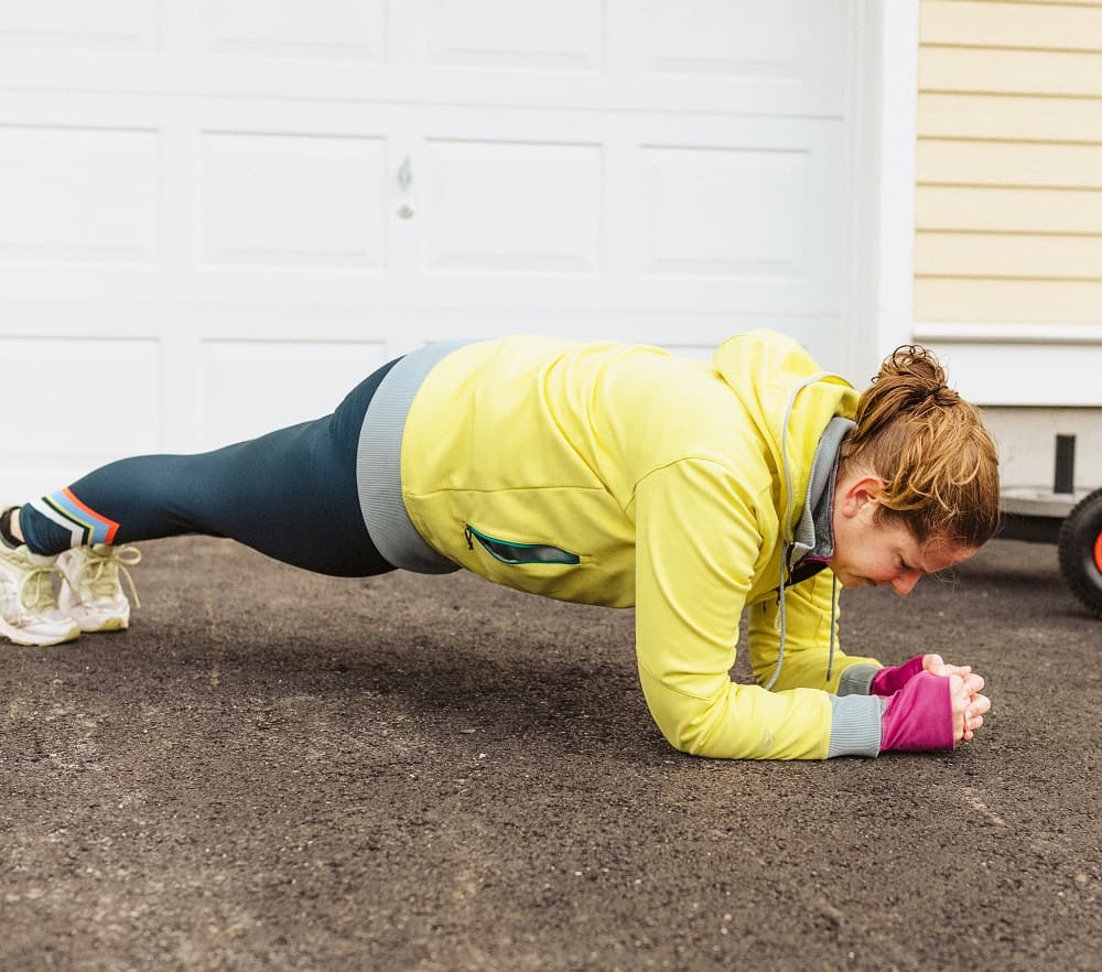 a woman doing forearm planks, a bodyweight exercise for beginners, outside