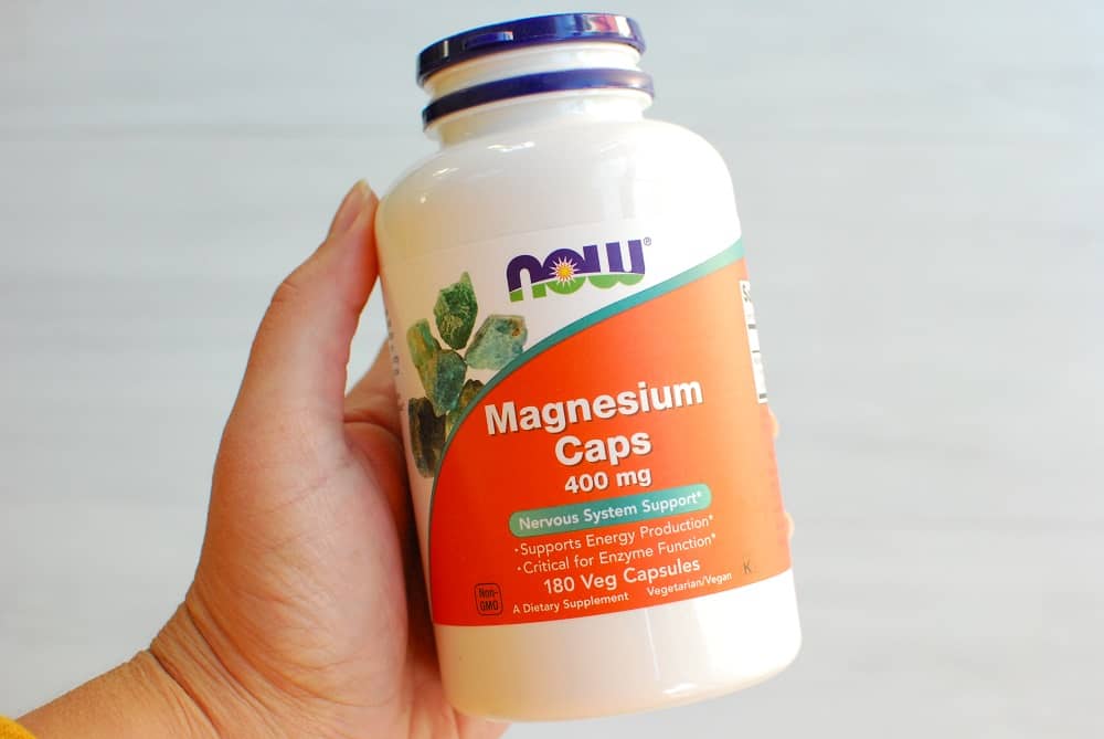 a magnesium supplement bottle in a woman's hand