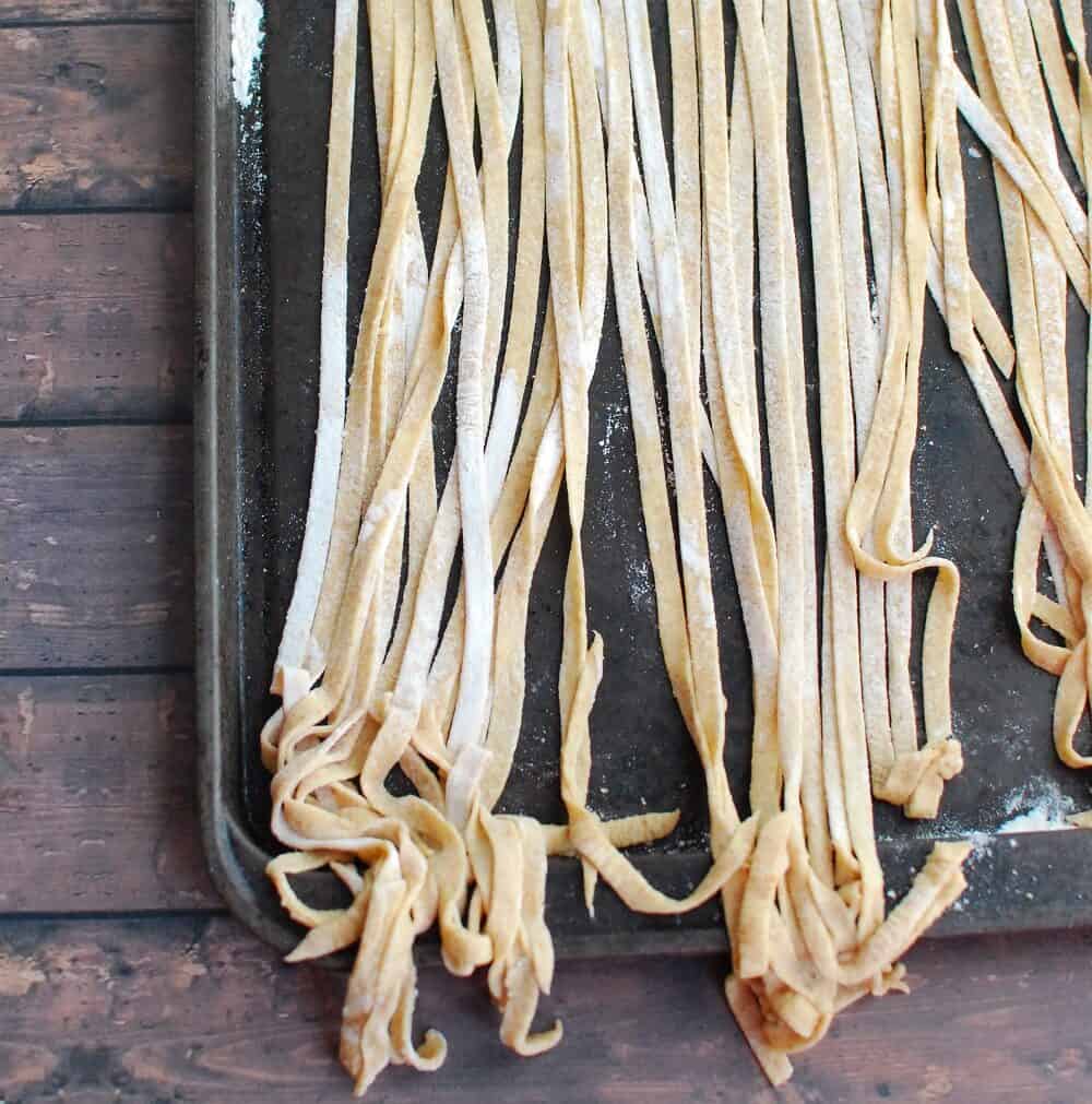 noodles drying on a floured baking sheet