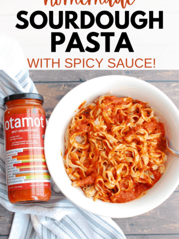 a bowl full of sourdough pasta tossed with tomato sauce, alongside a jar of sauce