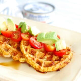 a tuna waffle topped with tomatoes, avocado, and balsamic