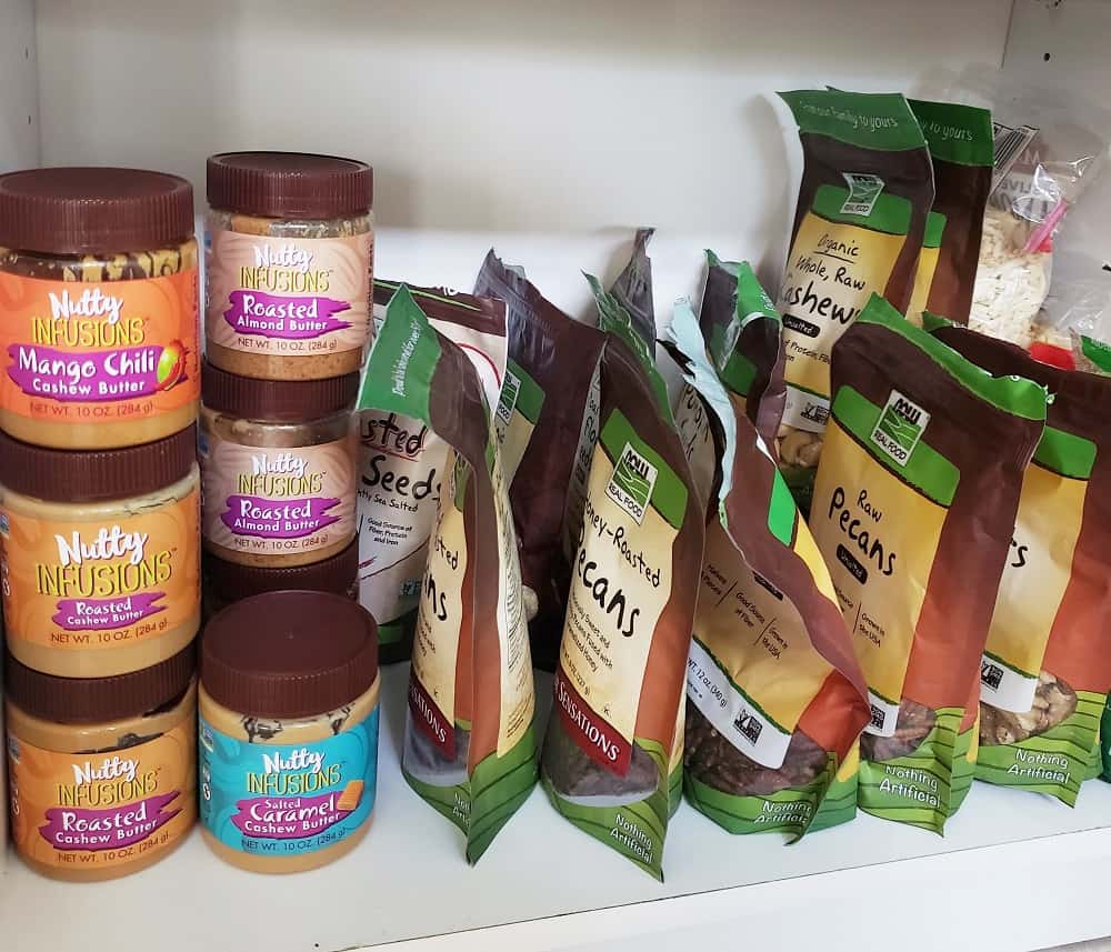 a shelf in a pantry with lots of different nuts and nut butters