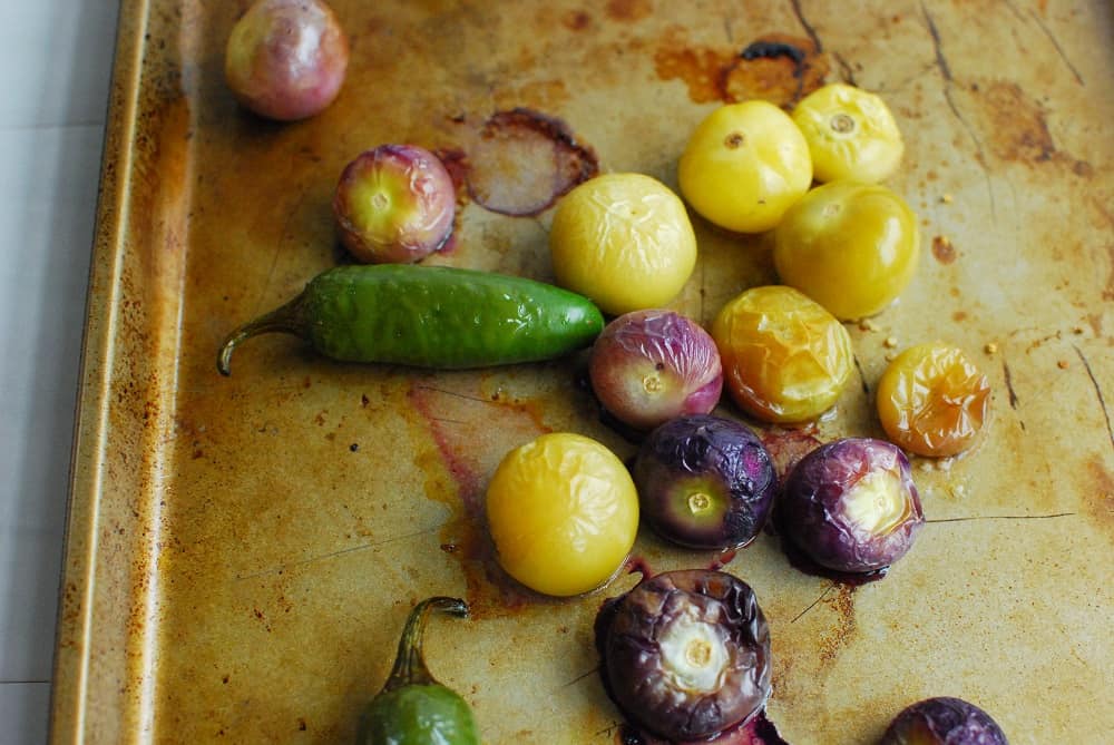 roasted jalapenos and tomatillos on a baking sheet