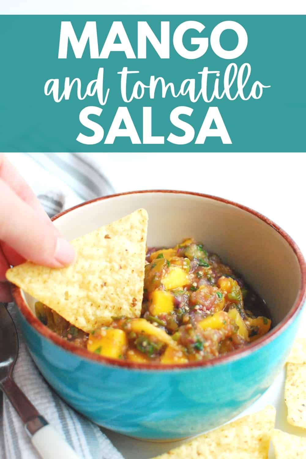 a woman dipping a chip in a bowl of tomatillo mango salsa