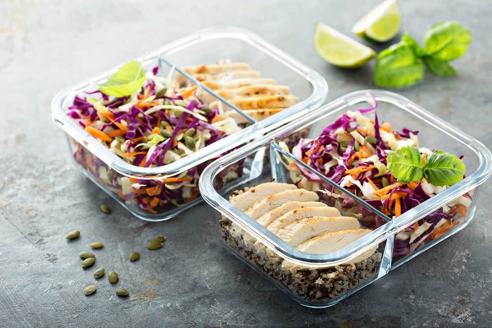 Healthy meal prep containers with quinoa, chicken and cole slaw