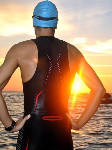 a triathlete facing the sea at sunrise, thinking about gifts they would love to receive