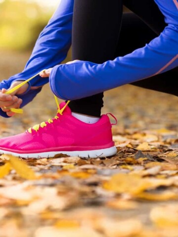 a woman tying her shoelaces getting ready to run a virtual turkey trot