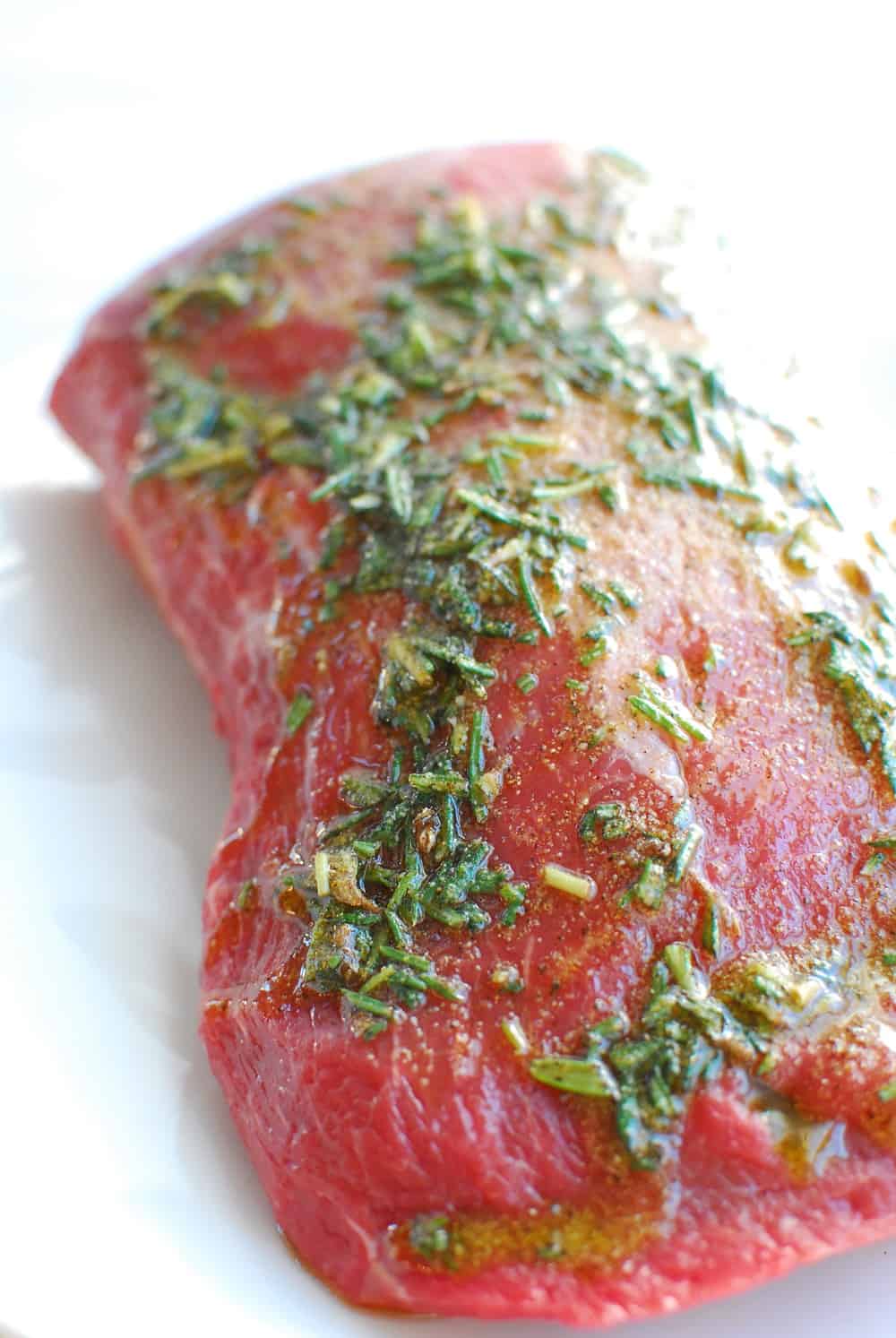 an eye of round roast rubbed with oil, rosemary, garlic, salt and pepper