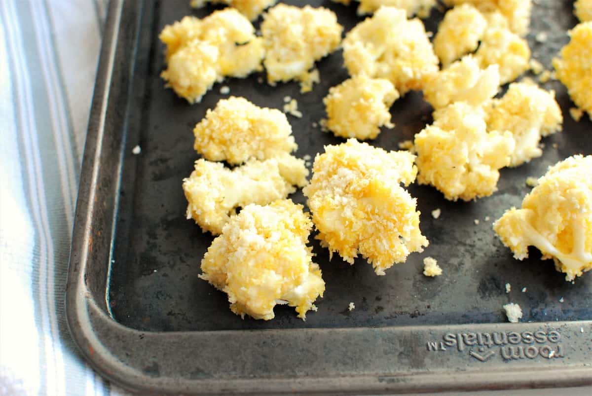 cauliflower coated in breadcrumbs on a baking sheet