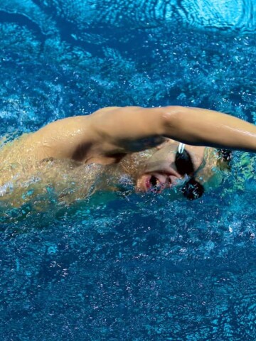 a male swimmer taking a breath during a freestyle stroke