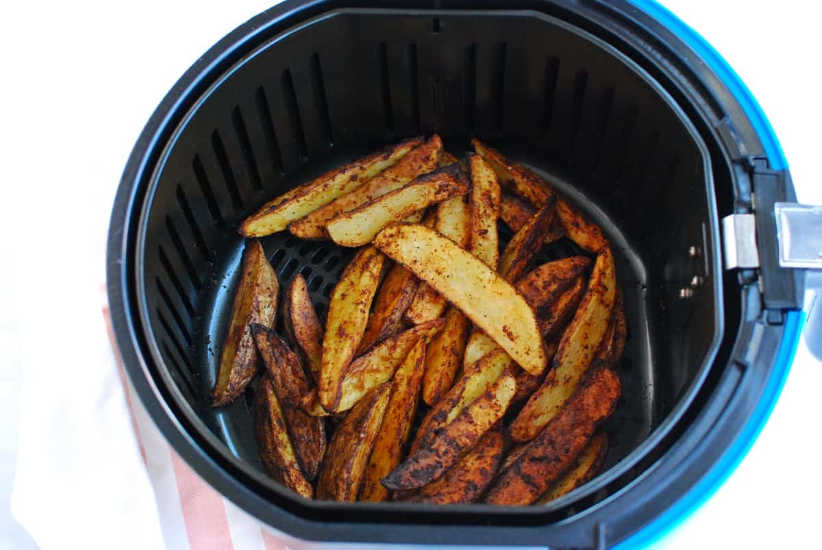 Potato wedges after just being cooked in the air fryer basket.