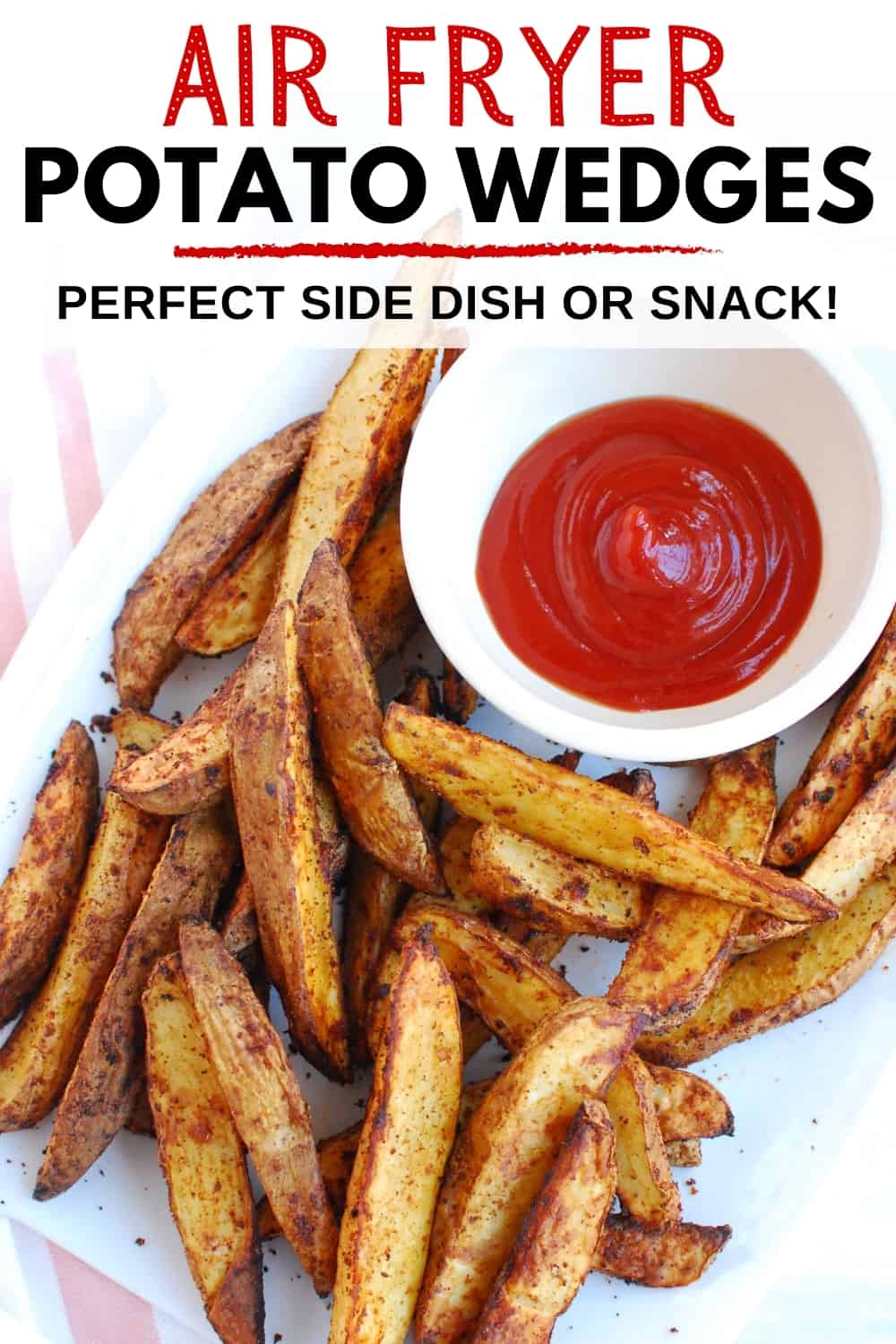 An overhead shot of air fryer potato wedges on a white plate with a small bowl of ketchup.