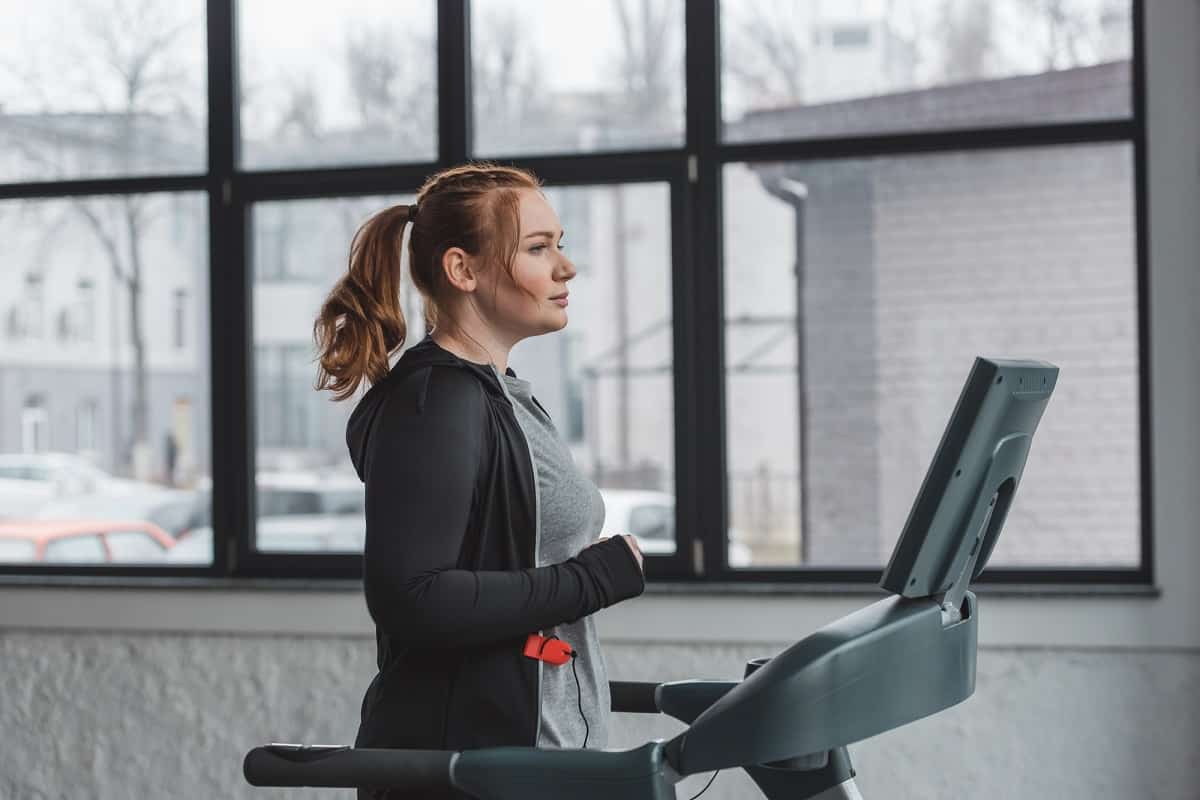 a woman walking on the treadmill doing a beginner workout