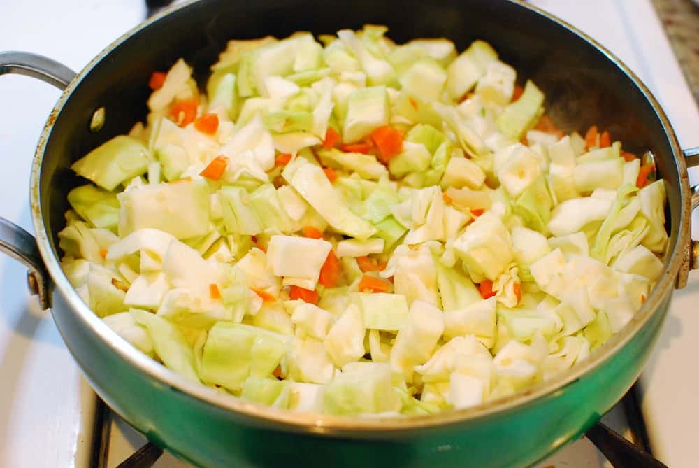 Cabbage, carrots, onion, and garlic in a pan.