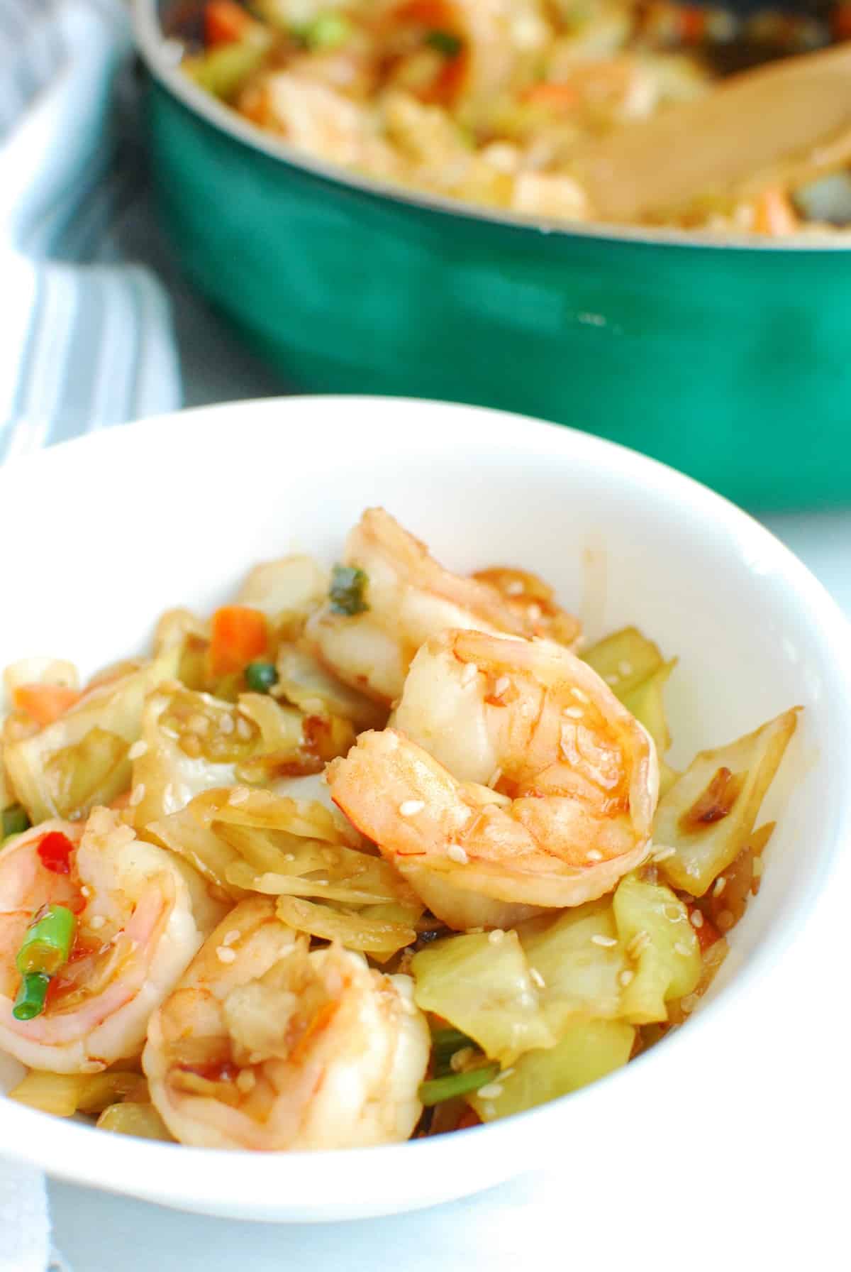 A white bowl filled with shrimp egg roll in a bowl, next to a fork.