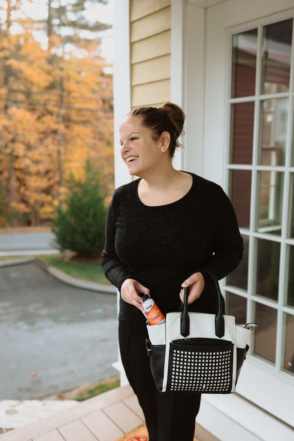 a woman taking a bottle of Vitamin D out of her purse