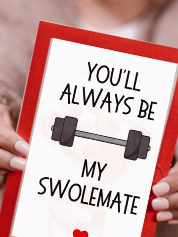 A woman holding a fitness Valentine's Day card with a red background.