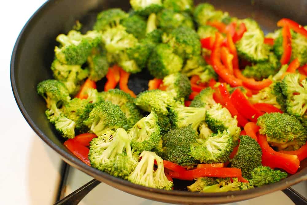 Broccoli and red bell peppers in the skillet.