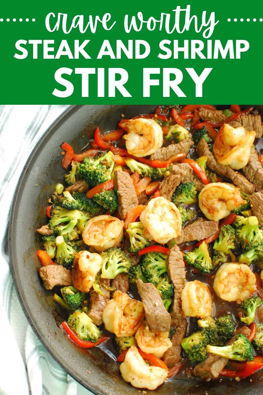 A skillet full of steak and shrimp stir fry.