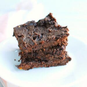 Three healthy fudgy butternut squash brownies stacked on top of each other.