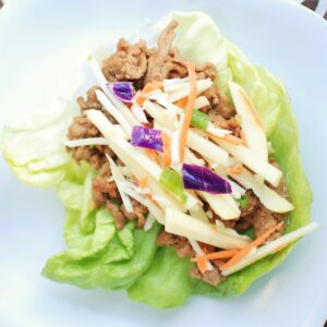 A hoisin turkey lettuce wrap on a white plate.