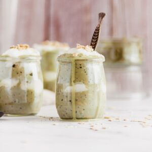 A jar of matcha overnight oats with a spoon inside.