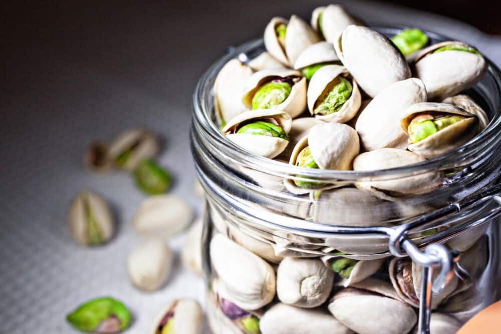 Pistachios in a clear glass jar.