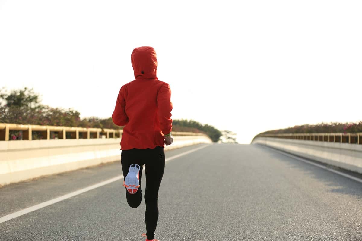 A woman running outside on a road.