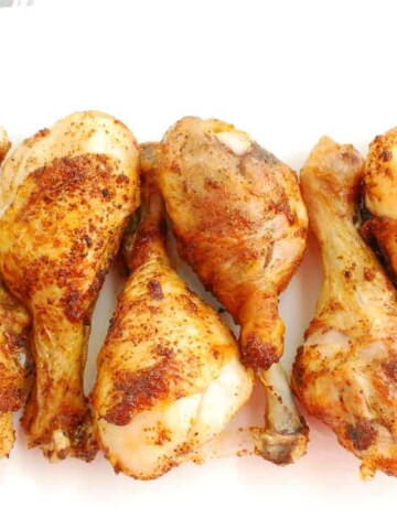 Air fryer chicken drumsticks on a white plate.