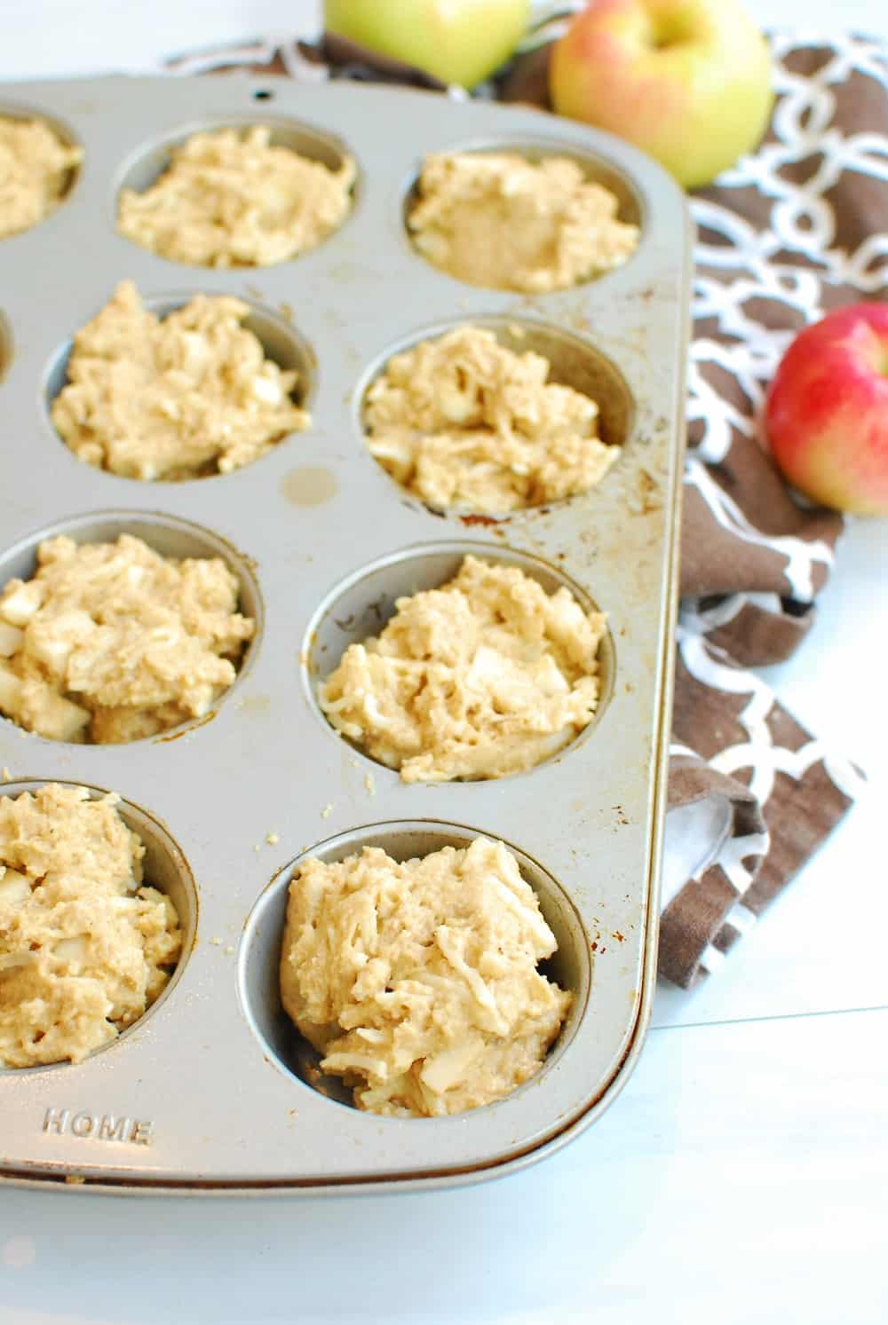 Muffin batter poured into a 12-count muffin tin.