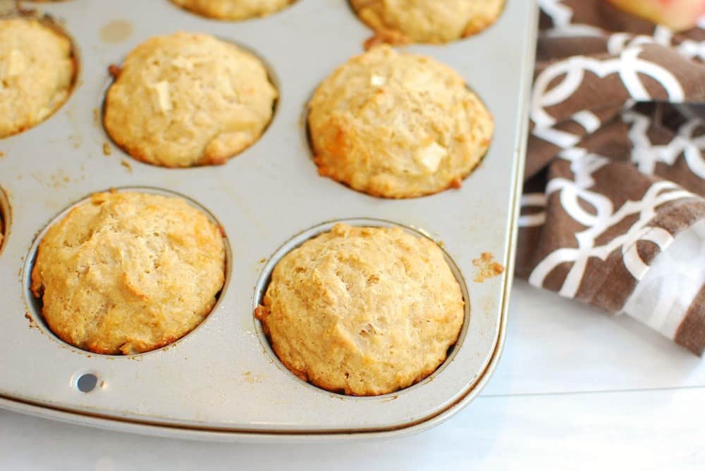 A muffin tin after baking the muffins, next to a napkin.