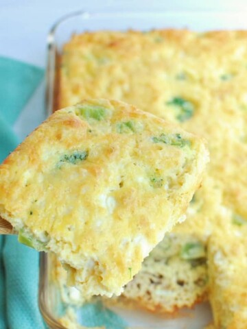 A wooden serving utensil holding up a slice of high protein breakfast casserole.