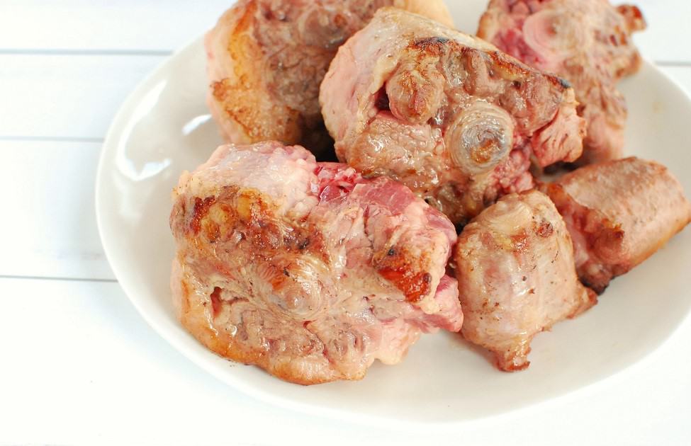 Seared oxtail set aside on a plate.