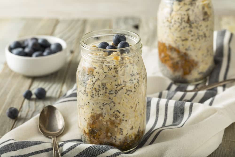 Overnight oats in a mason jar on top of a striped napkin.