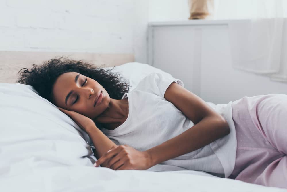 A woman laying in bed sleeping.