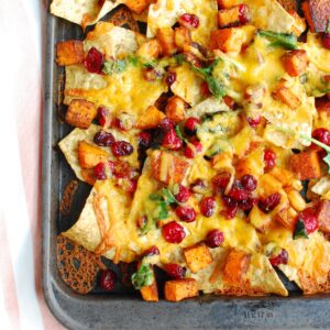 Close up of a sheet pan full of butternut squash nachos.