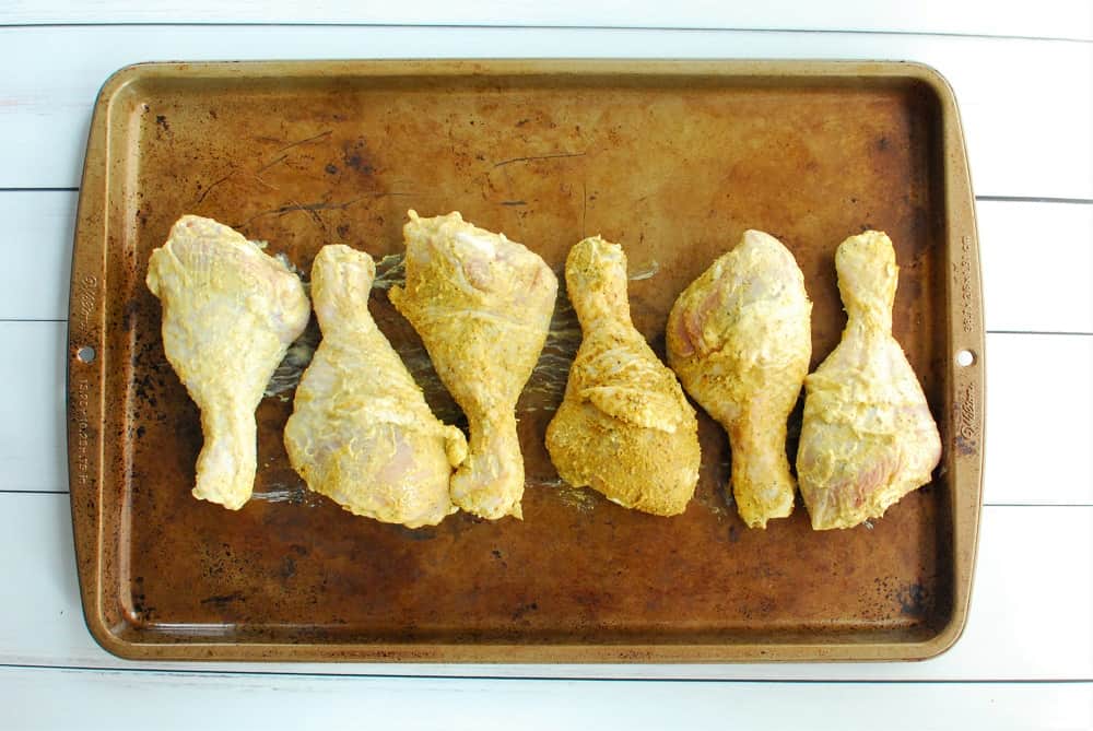 Chicken drumsticks on a baking sheet prior to cooking.