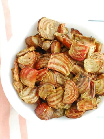 A white bowl full of roasted chioggia beets.