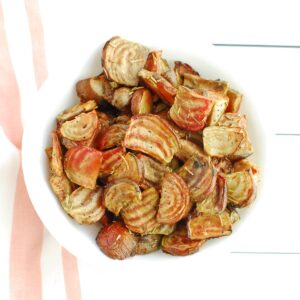 Overhead shot of a white bowl filled with roasted chioggia beets.