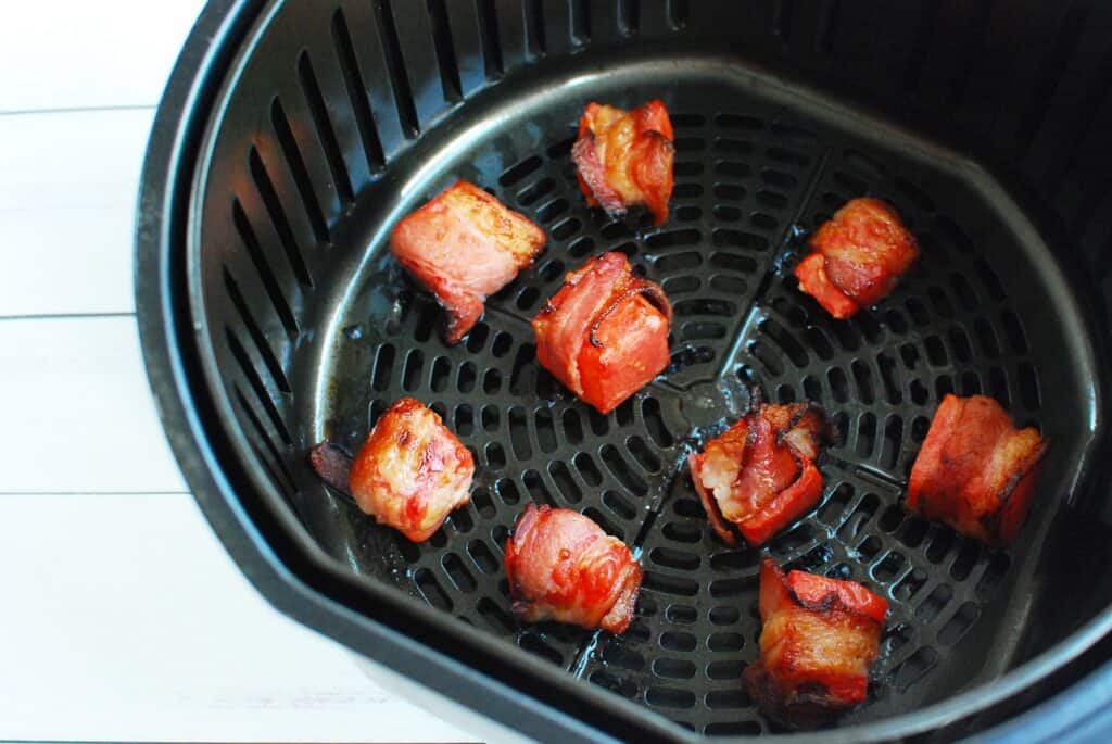 Cooked bacon wrapped watermelon in an air fryer basket.