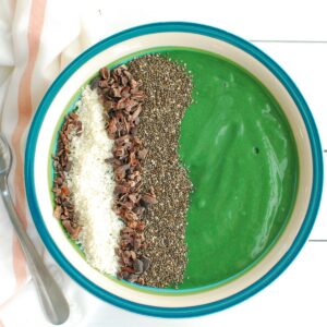 A spirulina smoothie bowl next to a napkin and a spoon.