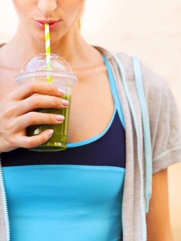 A vegan runner in athletic gear drinking a green smoothie.
